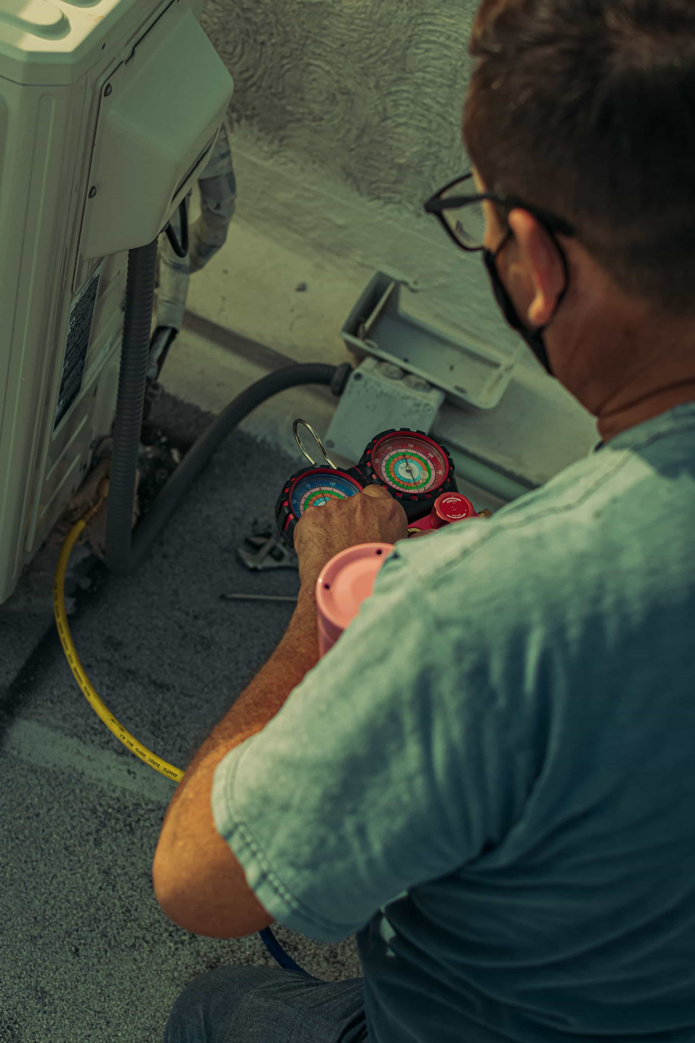 HVAC technician servicing an outdoor air conditioning condenser
